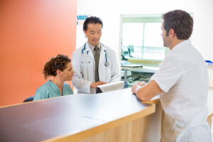 Doctor and nurse with patient at desk